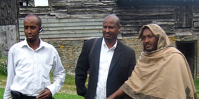 Somalis from Ocean Somali Community Centre in London pose in front of barns